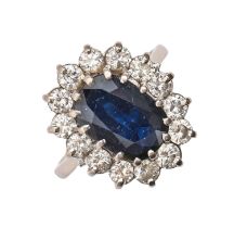 A sapphire and diamond ring, with 9 x 12mm oval sapphire in diamond surround, in 18ct white gold,