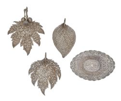 Three South East Asian leaf shaped silver dishes and an oval dish, on four feet, 20th c, various