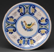 A French faience dish, 19th c, painted in a four colour palette with a bird and panelled border,