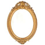 A Victorian oval giltwood and composition mirror, the bevelled plate in beaded surround and egg-