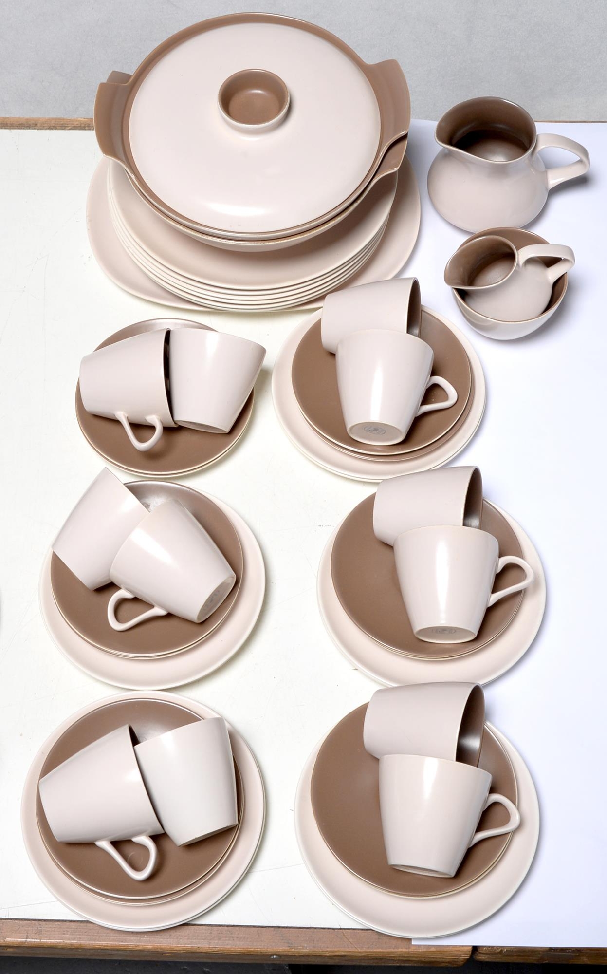 A set of twelve Poole teacups and saucers, printed marks, conforming dinner ware, the covered