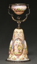 A Viennese silver gilt and painted enamel wager cup, early 20th c, in the form of a woman, her