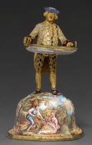 A Viennese giltmetal and painted enamel figure of a man carrying a tray, c1900, the high domed