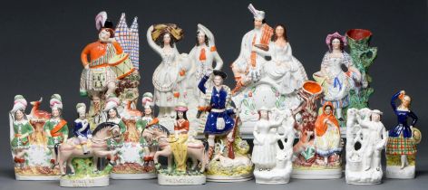 Thirteen Staffordshire flatback figures and groups, including spill holders, 19th c, largest 35cm