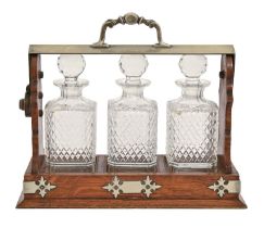 An EPNS mounted oak tantalus and three cut glass decanters and stoppers, c1900, 32cm h, by