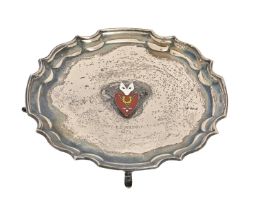 An Elizabeth II silver waiter, the field applied with a silver and enamel badge, on four feet,