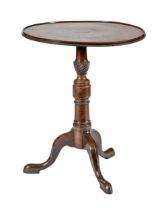 A George III mahogany tripod table, the tip-up top on oak block, pillar with wrythen fluted knop,