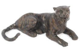 A cold cast bronze sculpture of a recumbent tiger.