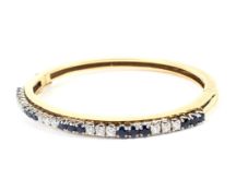 A Continental sapphire and diamond half-hoop hinged bangle.