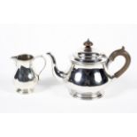 A silver teapot with horn handle and finial and matching cream jug.
