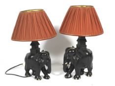 A pair of ebonised elephant table lamps.