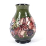 A Moorcroft Pottery Anemone pattern baluster green ground vase.