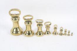 A graduated composite set of nine bell-shaped brass weights, 19th century and later.