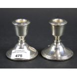 A pair of silver short round candlesticks with stepped borders. Hallmarks for Birmingham 1977, 7.