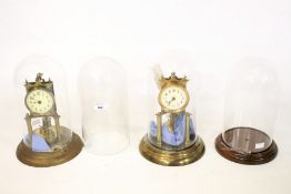 Two anniversary clocks under glass domes and two further glass domes.
