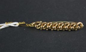 A yellow metal brooch. Modelled as interwoven links, 4.