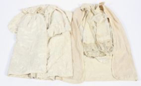 Two baby carrying capes. The first Victorian, in cream and partially lined in silk.