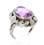 A 20th century white metal ring set with a large purple stone.
