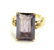 A yellow metal ring. Stamped '14K', set with an emerald cut colour change purple stone, size L, 4.