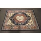 A large modern rug. Dark blue boarder with floral pattern in pink and grey. 270x190cm.