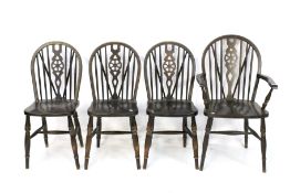 A contemporary set of three stained oak wheelback chairs and a single carver chair.