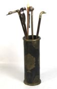 Five novelty walking canes in an ebonised stand.