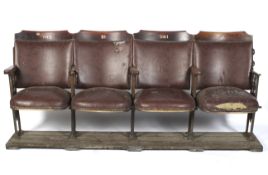 A set of four conjoined cast iron mounted cinema seats.