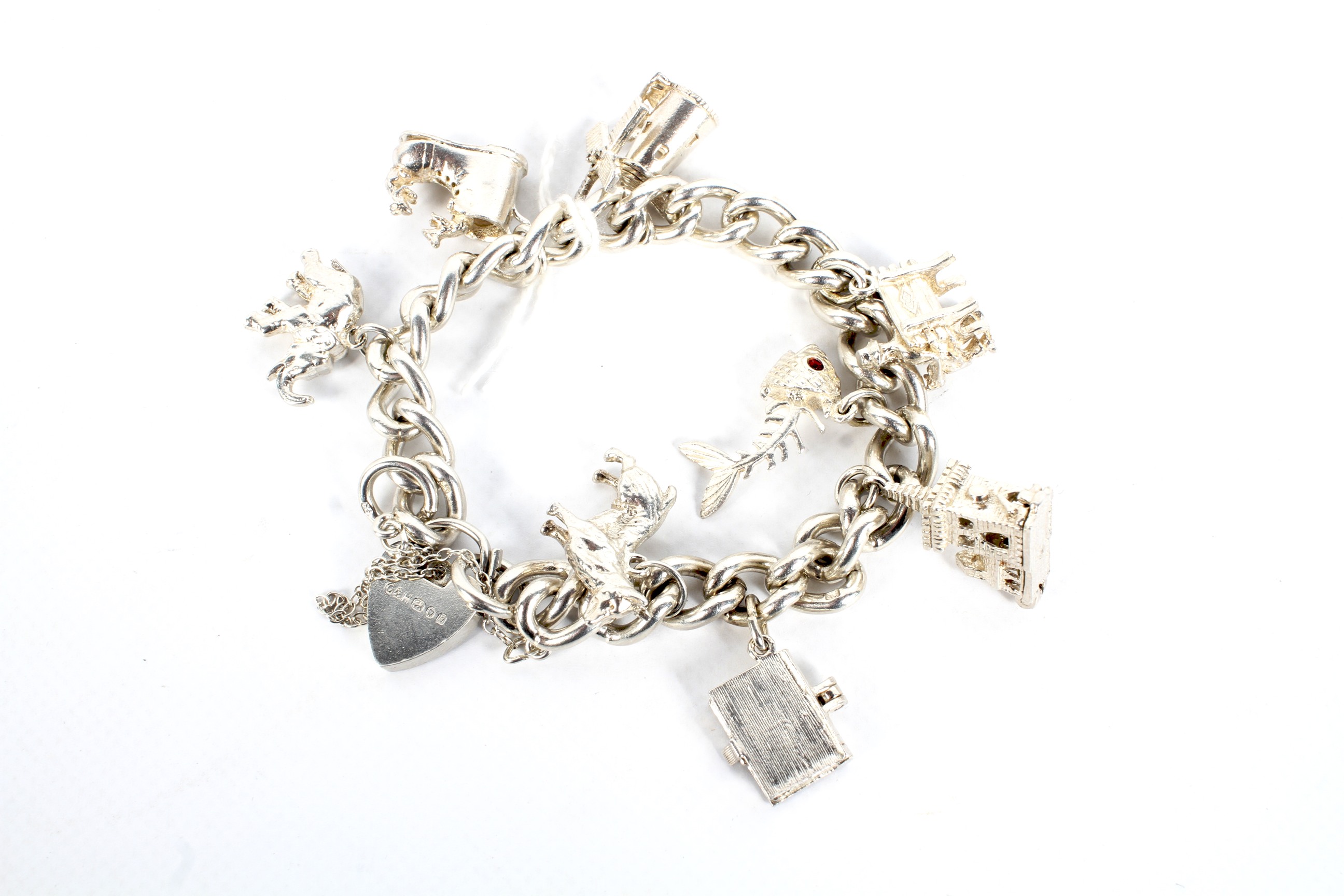 A silver charm bracelet with a heart lock and eight charms.