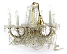 An electric chandelier ceiling light. With six branches, glass drops and swags.