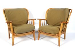 A pair of beech Ercol style spindle wingback elbow chairs.