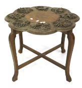A heavily carved top occasional table. The shaped top with plant and flower decoration.