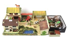 A vintage scratch built wooden toy farmyard with a collection of farm animals.