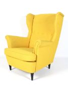 A modern Ikea modern Strandmon yellow upholstered wing back armchair.