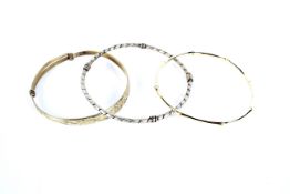 Three white metal bangles. Some with moulded and engraved decoration, 31.