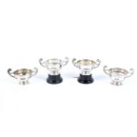 A set of four silver twin handled trophies.