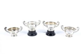 A set of four silver twin handled trophies.
