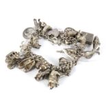A vintage silver charm bracelet with an engraved heart padlock.