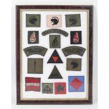 A framed and glazed collection of military patches.