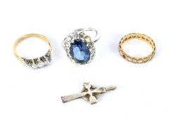 Three white metal stone set rings and a cross pendant.