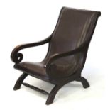 A brown leather steamer chair. On a stained oak X-frame with turned front stretcher.