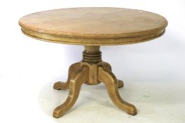 An oak circular dining table on single pedestal.