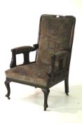 An Edwardian upholstered mahogany open armchair on cabriole legs.