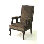 An Edwardian upholstered mahogany open armchair on cabriole legs.