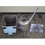 A vintage metal watering can, a sundial and a wooden basket with a single handle.