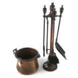 A copper pot and a set of four fireside tools.