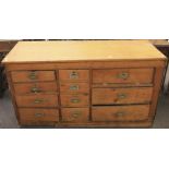 A large pitch pine kitchen/workshop chest. Of eleven assorted drawers with recessed handles,