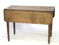 A Victorian oak drop leaf dining table on turned tapering legs.