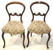 A pair of Victorian balloon back chairs with carved rail.