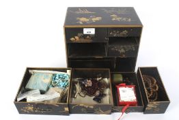 A Japanese lacquered jewellery box with drawers and contents.