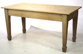 A light oak rectangular kitchen table on fluted tapering legs With cutlery drawer at one end.